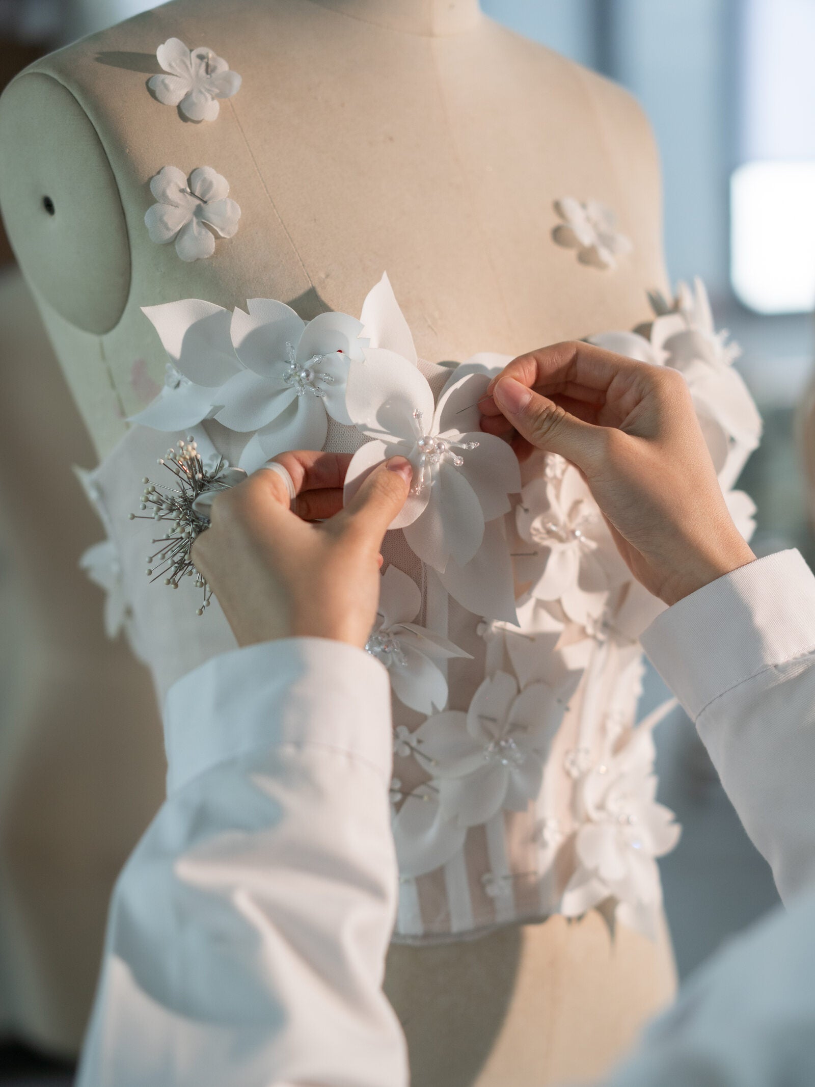 Floral appliques being sewn by hand