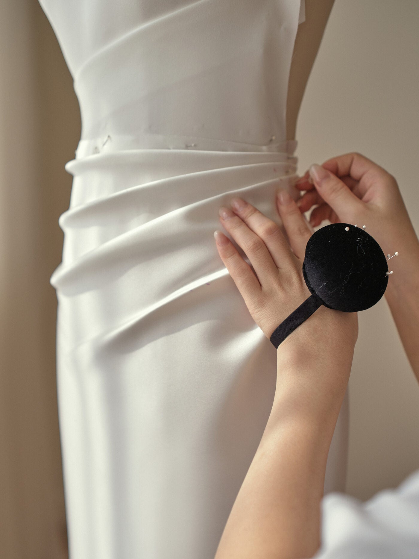 Bridal gown being carefully fitted by hand